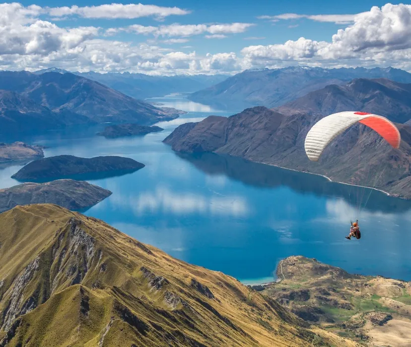 A paraglider drifting over Lake Wānaka, New Zealand
