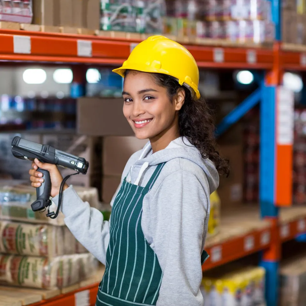 A warehouse worker scanning stock between the shelves