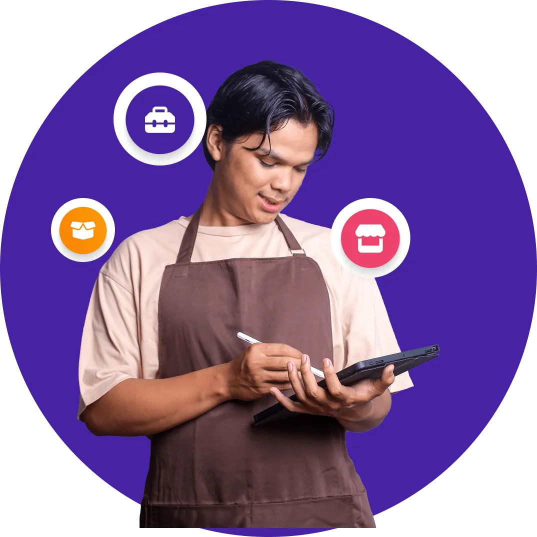 A shop owner in an apron taking an order on an iPad
